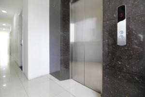 a elevator door with a remote control on a wall at Residence100 in Jakarta