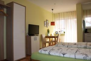 1 dormitorio con 1 cama, TV y mesa en Ferienwohnung Markmann, en Schwabach