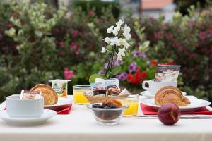 einen Tisch mit Teller mit Lebensmitteln und Obst in der Unterkunft Hôtel Le Dauphin in Arcachon