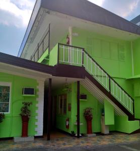 a green building with a staircase on the side of it at AMBIANZA APARTELLE in Manila