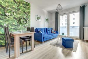 a living room with a blue couch and a table at Platinium Spectrum Apartment in Gdańsk