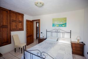 a bedroom with a bed and a chair in it at Casa sul lungomare di Forio d'Ischia - "Serpico sea & more" in Ischia