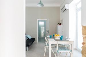 una cucina e una sala da pranzo con tavolo e sedie bianchi di Casa Trinacria a Marina di Ragusa