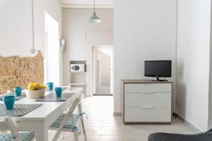 una cucina bianca con tavolo bianco e TV di Casa Trinacria a Marina di Ragusa