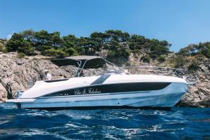 a white boat in the water next to a cliff at Chez Rosa - Cozy sea view openspace - 10mins from Belmond Caruso Ravello in Ravello