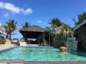 a man in a swimming pool at a resort at Damara Beachfront Resort in Baler