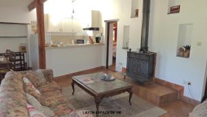 een woonkamer met een bank en een houtkachel bij Gîte Layon 6 places Moulin de la Placette in Faye-dʼAnjou