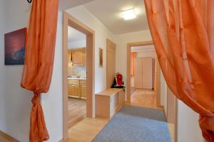 a hallway with an orange curtain and a kitchen at Haus Dejakom Mayrhofen in Mayrhofen