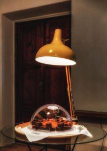 a lamp sitting on top of a glass table at Ca de Guelfi residenza d'epoca in Arezzo
