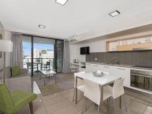 a kitchen with a dining room table and chairs at Atrio Apartments in Brisbane