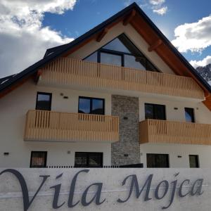 uma casa com um sinal em frente em Vila Mojca - Apartmaji Lena em Kranjska Gora