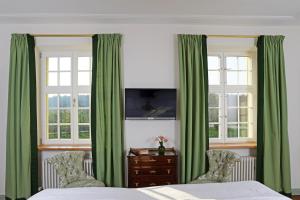 1 dormitorio con cortinas verdes, 1 cama y vestidor en Fischerhaus en Salem
