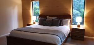 Rosa Glen的住宿－賈拉格羅夫森林度假木屋，一间卧室设有一张大床和两个窗户。