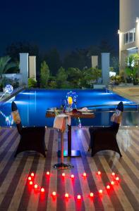 - une table et des chaises sur la terrasse la nuit dans l'établissement Swiss-Belhotel Pangkalpinang, à Pangkal Pinang