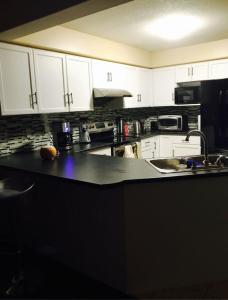 a kitchen with white cabinets and a black counter top at Sweet dreams in Guelph
