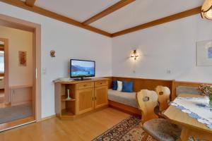 a living room with a bed and a television at Haus Dejakom Mayrhofen in Mayrhofen