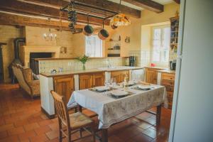 uma cozinha com uma mesa com uma toalha de mesa branca em La ferme de Bousserand em Pontours