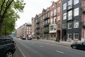 a city street with buildings and cars parked on the street at Clean and modern nassau canal apartment in Amsterdam
