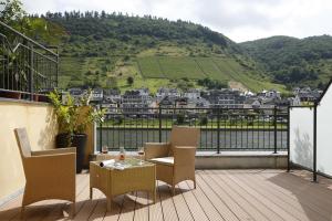 a balcony with chairs and a table with a view at Hotel Karl Noss in Cochem