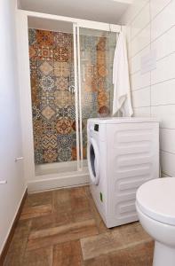 a bathroom with a toilet and a washing machine at Veranda sul Mare in Castellammare del Golfo
