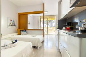cocina y sala de estar con 2 camas en Apartamentos Internacional Arysal, en Cambrils