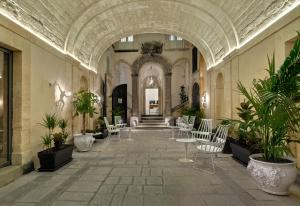 a hallway with chairs and potted plants in a building at A.D. 1768 Boutique Hotel in Ragusa