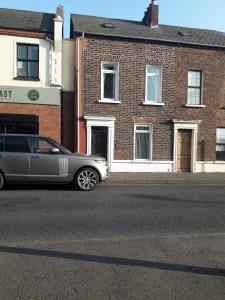 een zilveren limo geparkeerd aan de kant van een straat bij Titanic Sailortown Belfast City Centre townhouse in Belfast