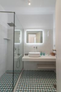 a white bathroom with a sink and a shower at Flora's Houses Mykonos in Klouvas