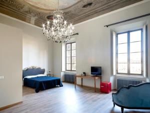 a bedroom with a blue bed and a chandelier at B&B Stupido Hotel in Florence