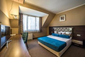 a hotel room with a bed and a television at Business Hotel Plovdiv - Central Location in Plovdiv