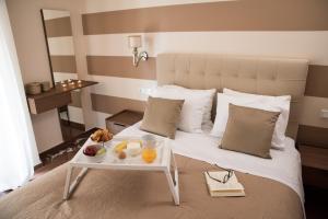ein Hotelzimmer mit einem Bett und einem Tablett mit Obst darauf in der Unterkunft AT.thea ATHENS BOUTIQUE APARTMENTS in Athen