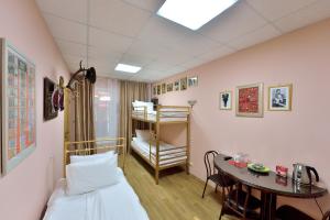 a small room with a bed and a table at Mini-Hotel Pushkin in Blagoveshchensk