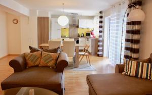 a living room with two couches and a kitchen at Apartmán Amália in Banská Bystrica