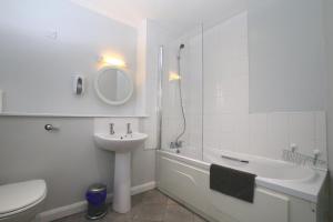 La salle de bains est pourvue d'un lavabo, de toilettes et d'une douche. dans l'établissement Library Square Penthouse, à Belfast