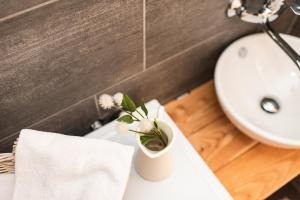 a bathroom with a sink and a vase with flowers in it at Il Bosco apartment in Arco