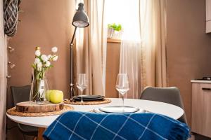 a dining table with two wine glasses and a blue cushion at Il Bosco apartment in Arco