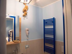 ein Bad mit einem Spiegel und einem Haartrockner an der Wand in der Unterkunft Appartamenti Vale Mare in Chioggia