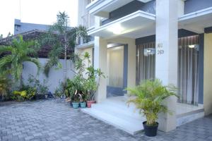 a building with potted plants in front of it at RedDoorz Syariah near Jogja City Mall 2 in Yogyakarta