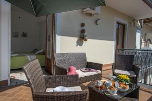 patio con sedie, tavolo e ombrellone di Appartamenti Aria di Verde ad Agerola