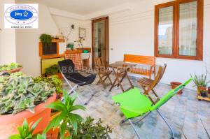 a living room with a table and chairs and plants at Babbai Giommi in Alghero