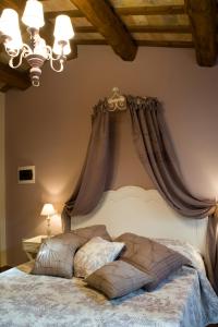 Schlafzimmer mit einem Bett mit Vorhängen an der Wand in der Unterkunft Casa Di Mi in Serrungarina