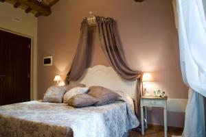 ein Schlafzimmer mit einem großen Bett mit Baldachin in der Unterkunft Casa Di Mi in Serrungarina