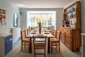 a kitchen and dining room with a wooden table and chairs at 7 Whinlands in Thorpeness