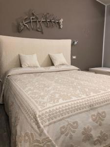 una camera da letto con un grande letto e un piumone bianco di La Locanda di Piazza a Santa Teresa di Gallura
