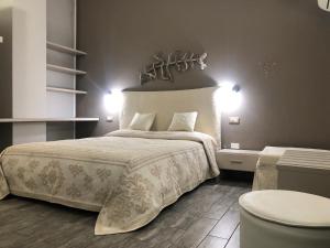 a bedroom with a bed and two lights on the wall at La Locanda di Piazza in Santa Teresa Gallura