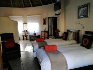 a bedroom with two beds and a chair in a room at Elephants Footprint Lodge in Colchester