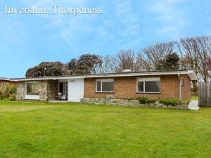 a brick house with a grass yard at Invershin -Aldeburgh Coastal Cottages in Thorpeness