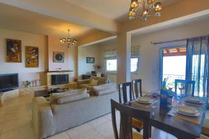 a dining room and living room with a table and a couch at Villa Dimeli in Barbati