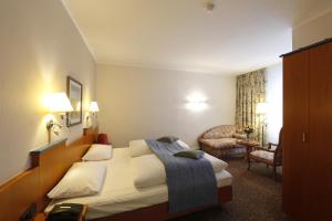 a hotel room with a bed and a chair at Hotel Karl Noss in Cochem