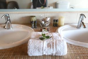 a bathroom with two sinks with towels on the counter at Villa Dimeli in Barbati +19 photos